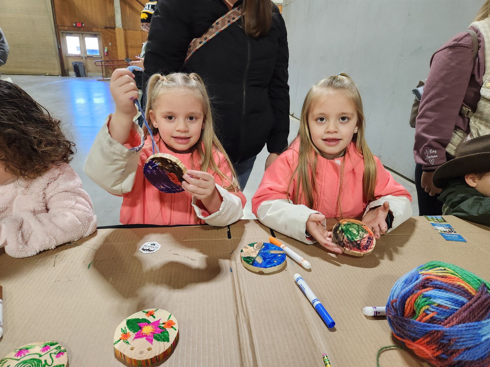 Two young outdoor enthusiasts show off their wood cookie necklaces.
