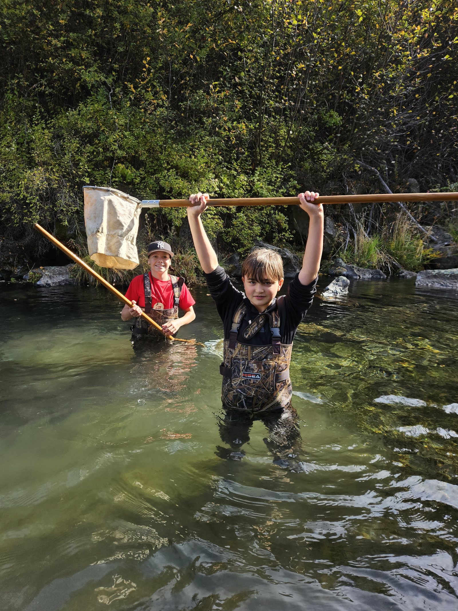 Camper holding up a ‘D’ net while wearing new waders