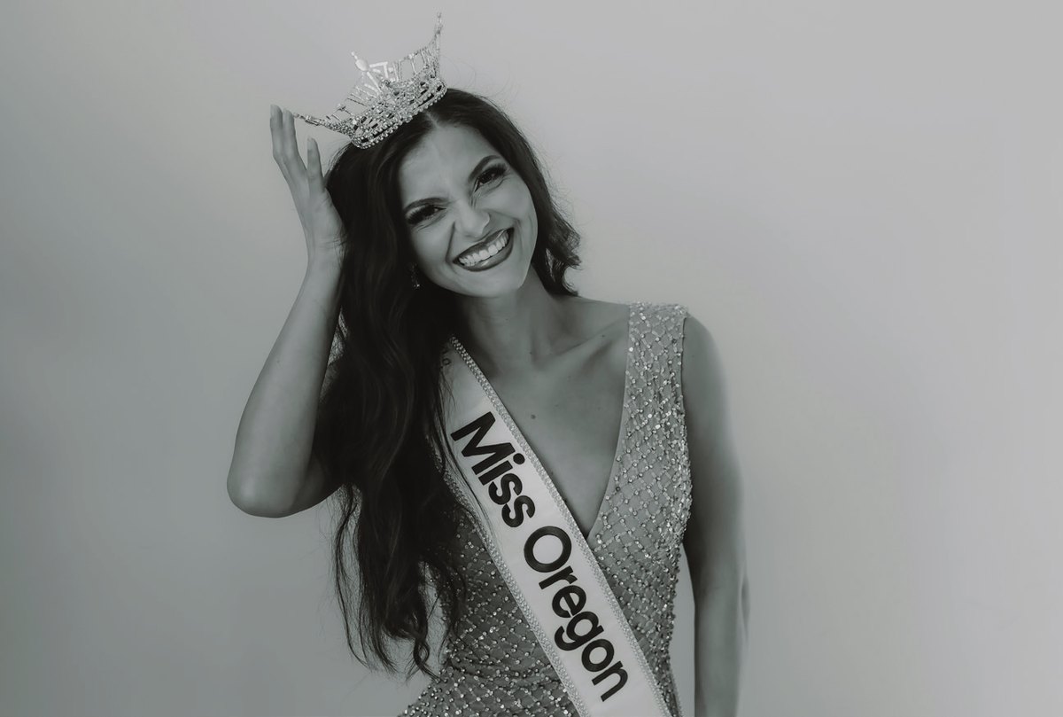 Black-and-white portrait of Allyssa Defillipo in a beaded evening gown wearing the Miss Oregon crown and sash