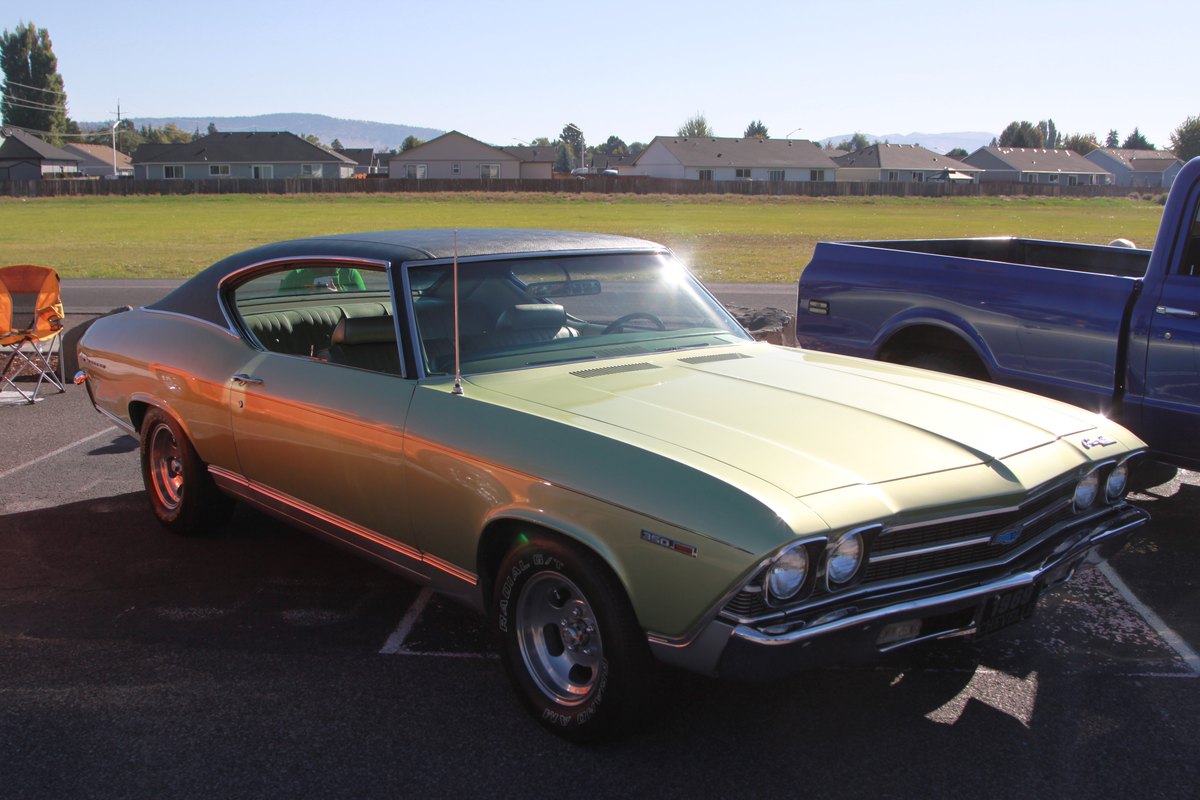 A muscle car parked on the grass beside the field at Crosspoint Christian School