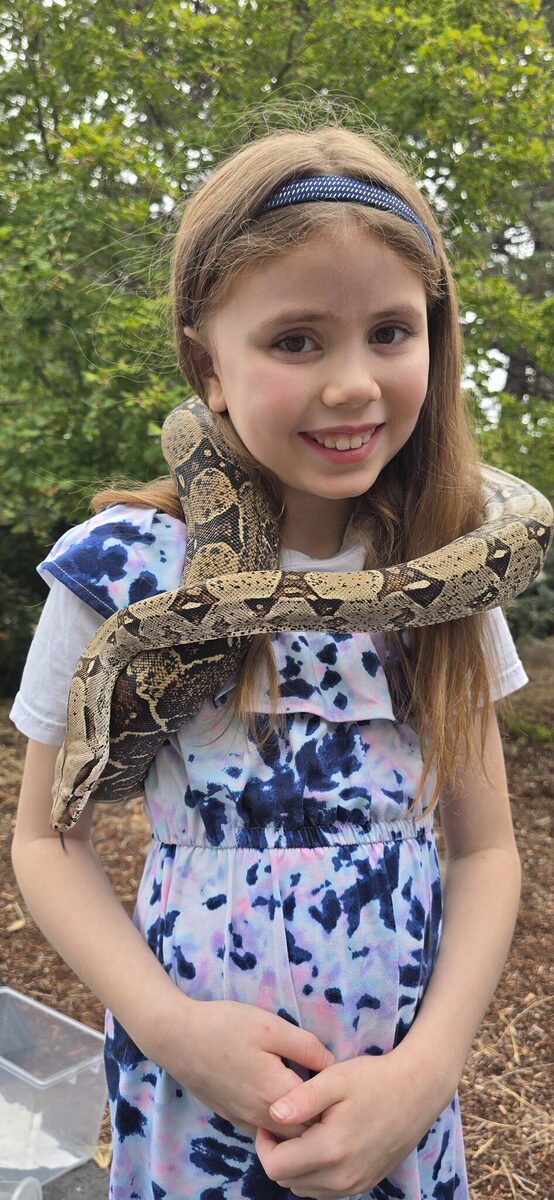 A boa constrictor across the shoulders and a great big smile