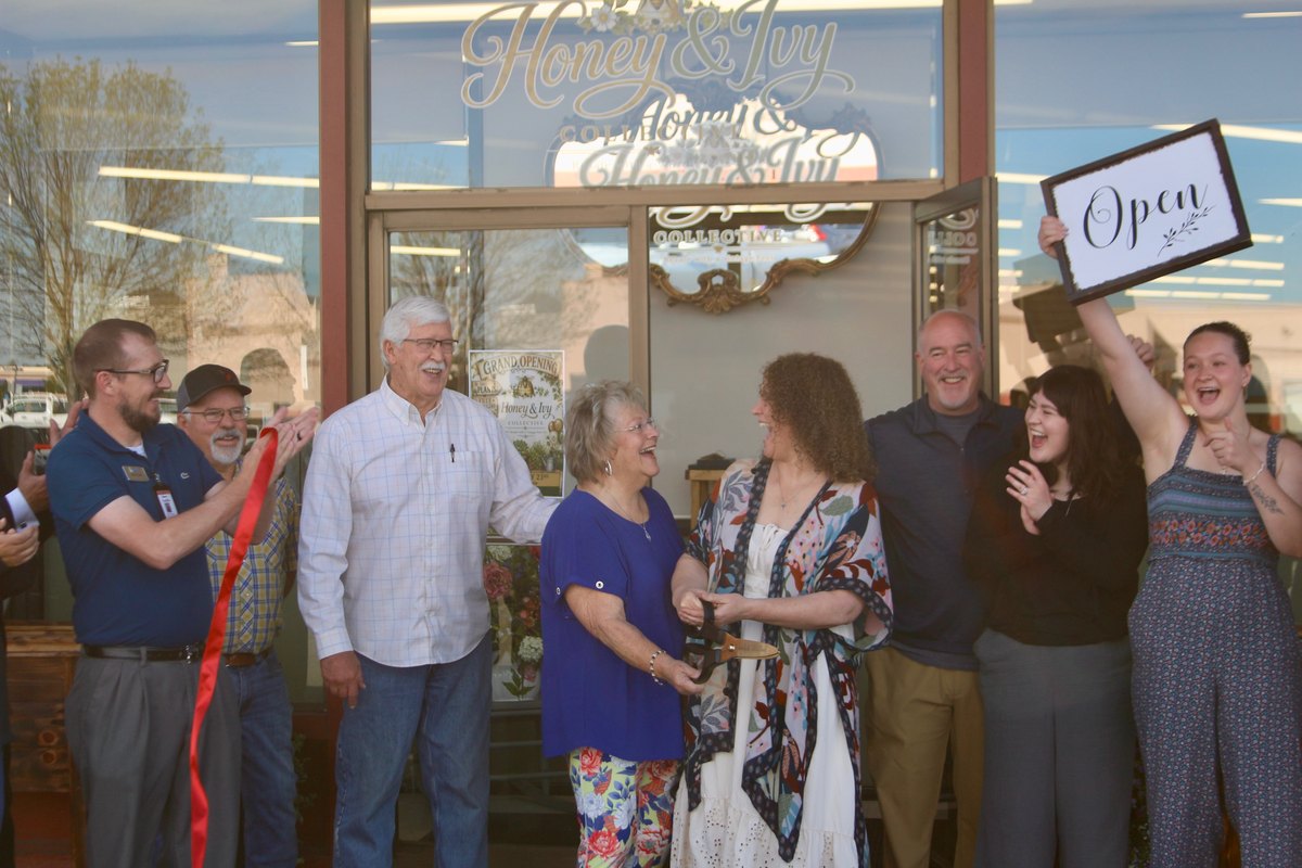 A ribbon-cutting crowd gathers outside the Honey & Ivy Collective storefront on opening day