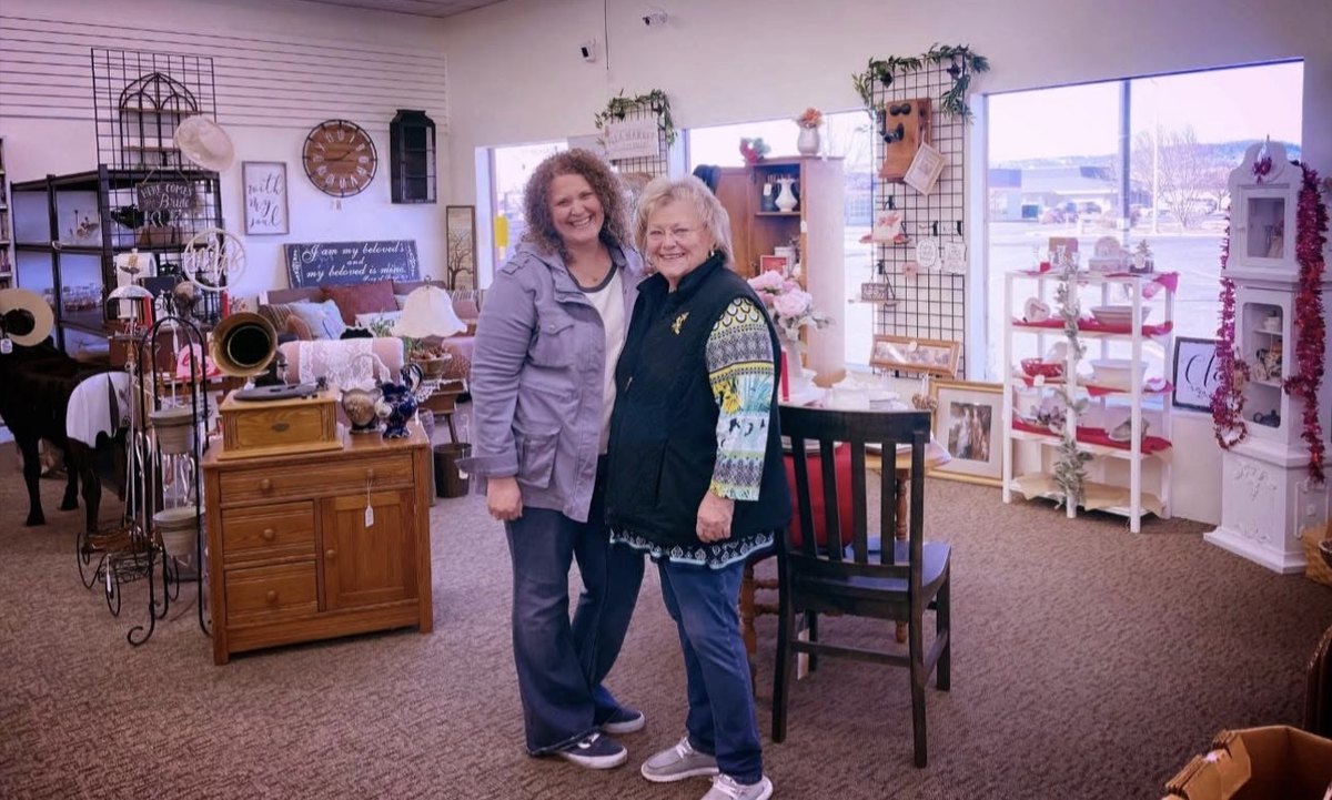Two people stand among the antiques and curated resale displays inside Honey & Ivy Collective