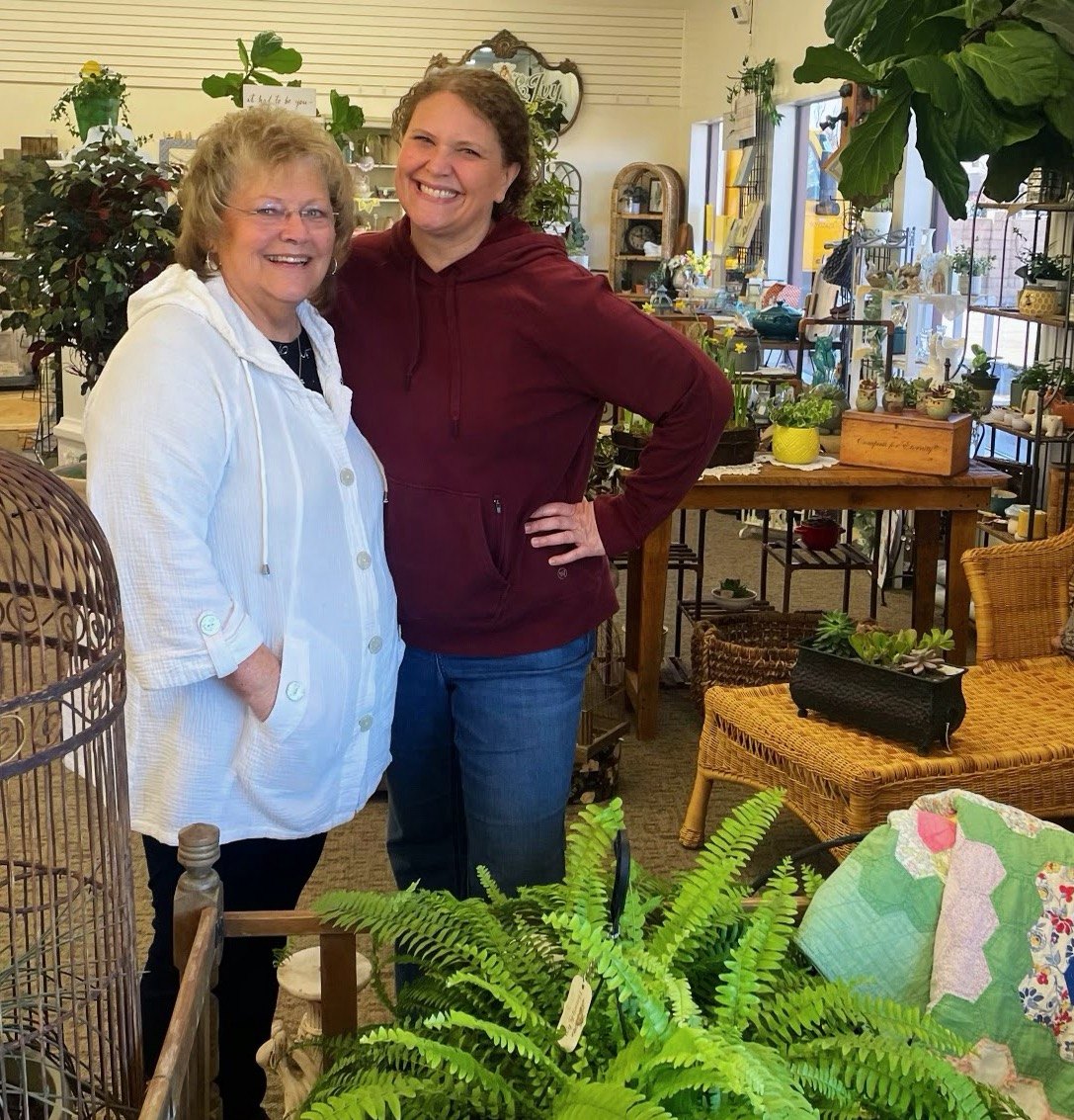 Vintage furniture, decor and hanging plants fill a corner of Honey & Ivy Collective