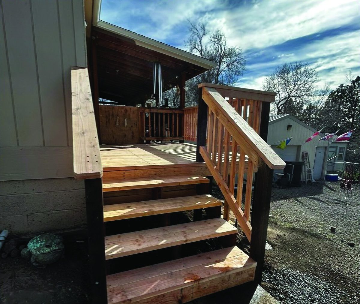 Wooden stairway and landing leading to a home entrance, built by KB Premier Construction