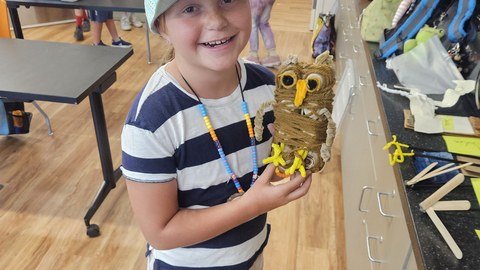 A KOSS camper showing off her model of a great horned owl