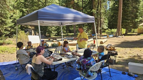 Klamath Tribes Elder Perry Chocktoot teaching flintknapping at KOSS Survival Skills Camp